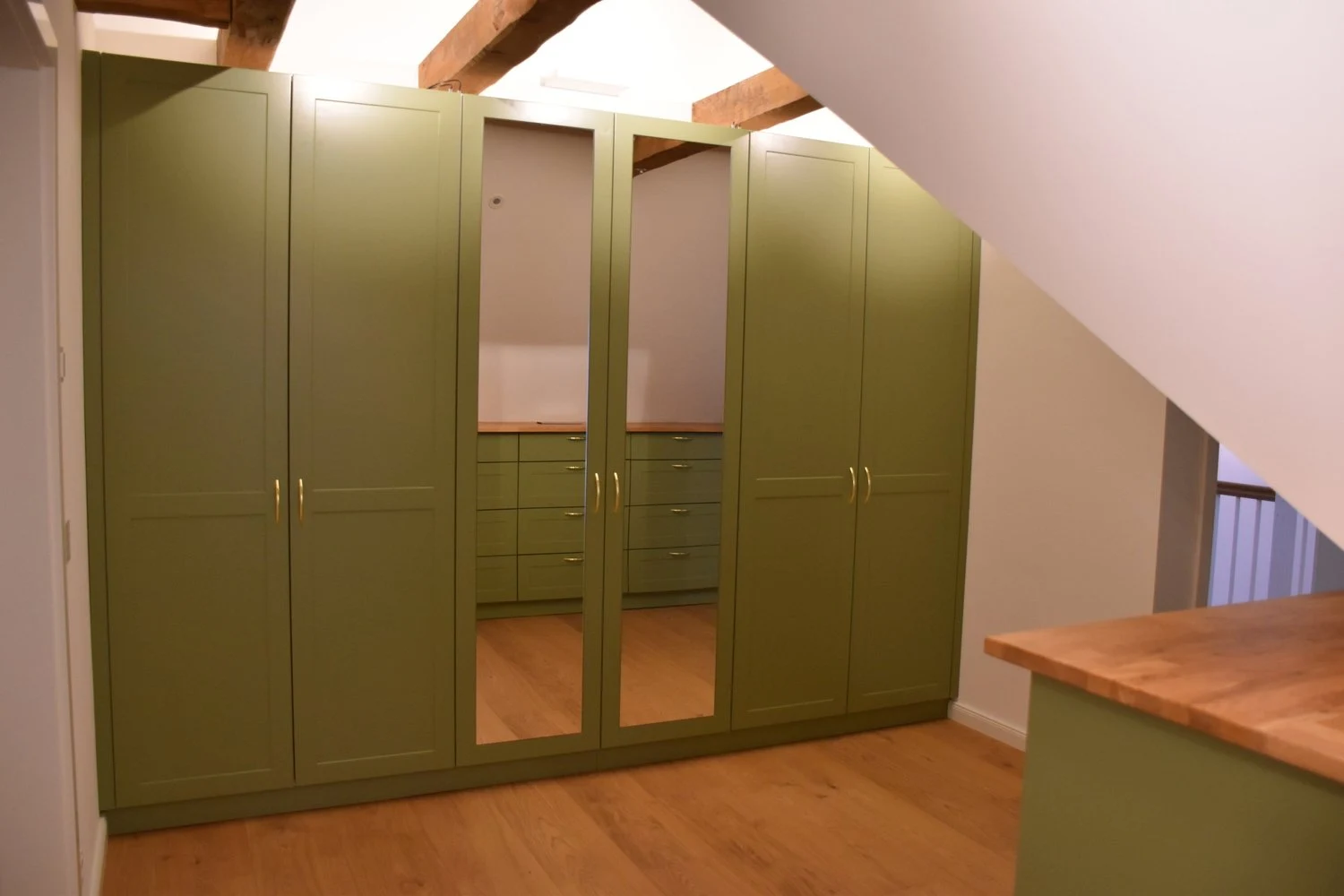 Grüner Einbauschrank unter einer Dachschräge