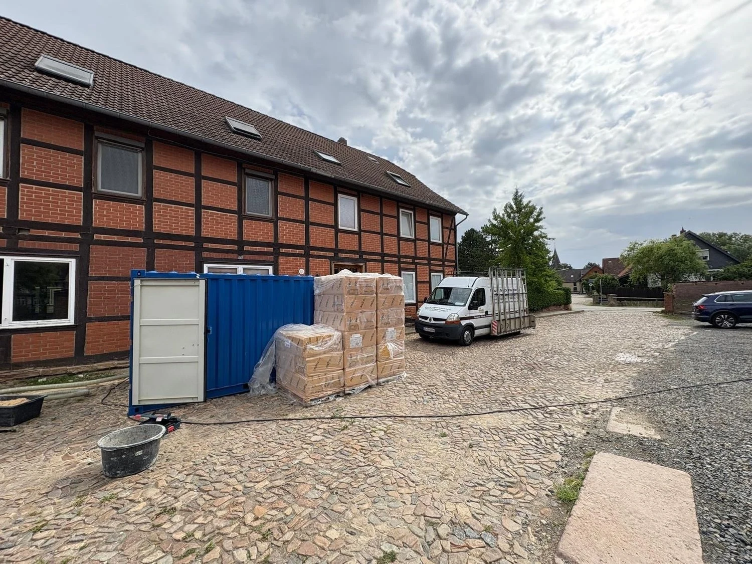 Bereitgestelltes Dämmmaterial vor einem Fachwerkgebäude